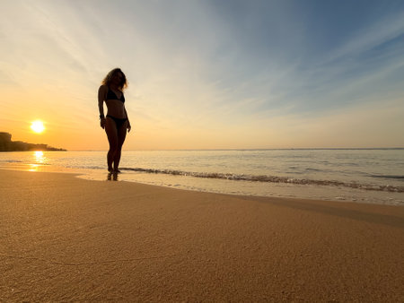 Silhouette of young woman relaxing at the sandy beach. Summer vacations conceptの写真素材