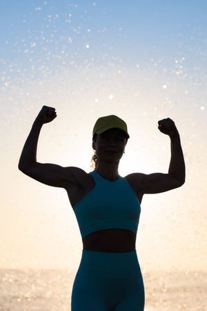 Fit happy woman posing at the beach. Silhouette of female against sea and sky background. Summer...