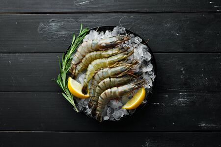 black tiger prawns with lemon on ice. Seafood. Top view. On a black background. Free copy space.の写真素材