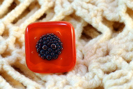 origina red glass handmade ring on knitted backgroundの写真素材