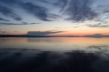Tranquility scenic lake in the twilight in pattern shadows clouds and afterglow sunlight