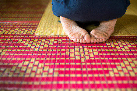 Meditation in the temple, feet on the rug for meditationsの写真素材