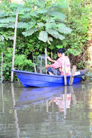 fisherman with kind of bamboo fish-trap with a narrow neck in canal,Thailandの写真素材