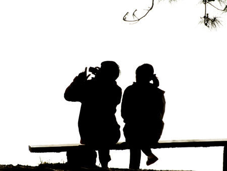 silhouette couple love sitting  on  benchの写真素材