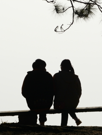 silhouette couple love sitting  on  benchの写真素材