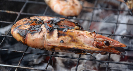 grilled shrimps with flames in background の写真素材
