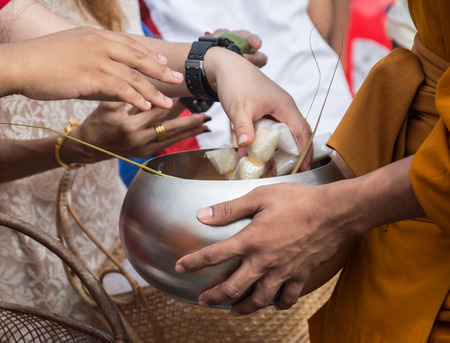 Buddhist monks are given food offering from people for End of Buddhist Lent Dayの写真素材
