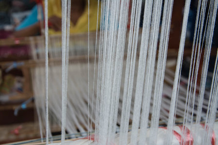 Woman weaving silk in traditional way at manual loom. Thailand