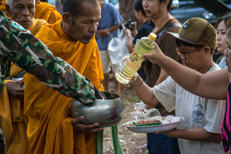 Prachuap Khiri Khan, THAILAND - APRIL 13 : Buddhist monks are given food offering from people for Songkran day or Thai New Year Festival . on April 13, 2016 in Prachuap Khiri Khan, Thailand.のeditorial素材