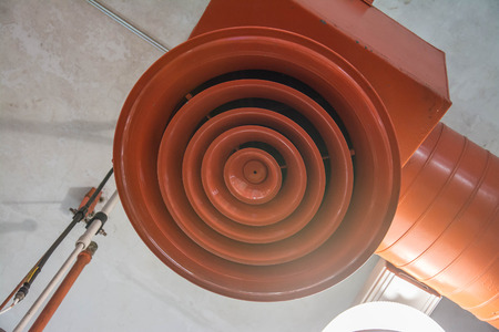 orange circular air ventilation duct on the ceilingの写真素材