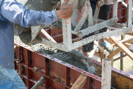 worker pouring  concrete  works at construction site