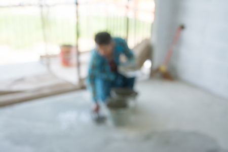 Blurred image of plasterer concrete worker at floorl of house constructionの写真素材
