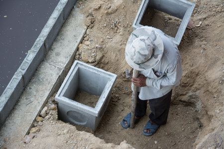  workers with concrete pipe stacked sewage water system aligned on site.