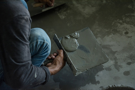 plasterer concrete worker at wall of house construction の写真素材