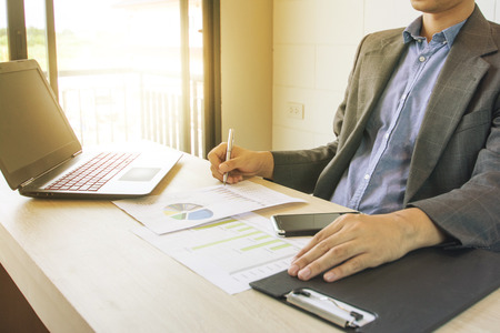 Business man working  with laptop and documents on wood tableの写真素材
