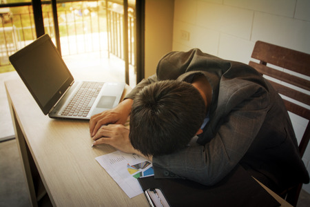 stressed business man on wood tableの写真素材
