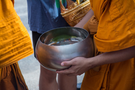 Buddhist monks are given food offering from people for End of Buddhist Lent Dayの写真素材