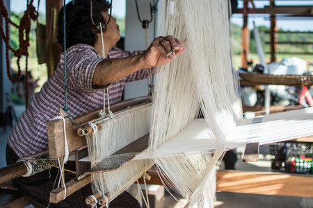 Nan, Thailand - December 16, 2016: old woman weaving silk in traditional way at manual loom. Thailandのeditorial素材