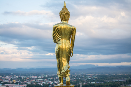 Golden Buddha standing on a mountain at sunset twilight  in Nan Province, Thailand.の写真素材