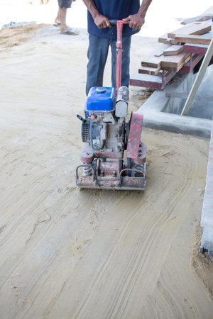 Worker use vibratory plates seals the base sand