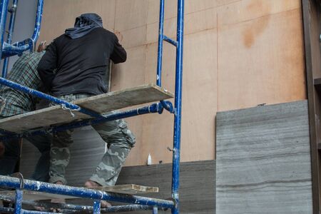 laying marble on wall, installing marble  in construction site.の写真素材
