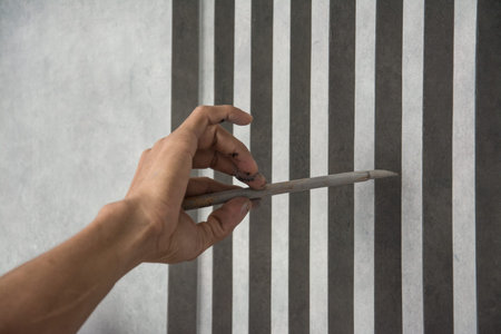 hand holding a brush  paint on a wooden furniture 