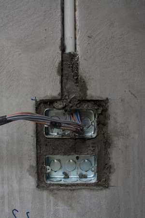 electric system on wall in construction site ,outlet with iron pipesの写真素材