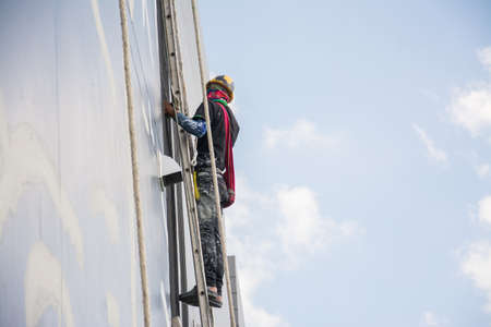 Painters and harnesses hanging high building at construction site,hand brush color work conceptのeditorial素材