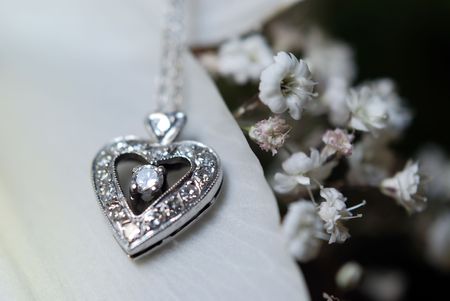 Close up to diamond heart shaped necklace on flower petalの写真素材
