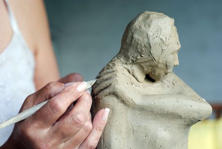 Close up to woman artist hands while she is creating a sculptureの写真素材