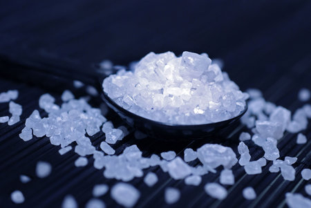 sea Salt on black spoon, studio shot blue filtered with spot light