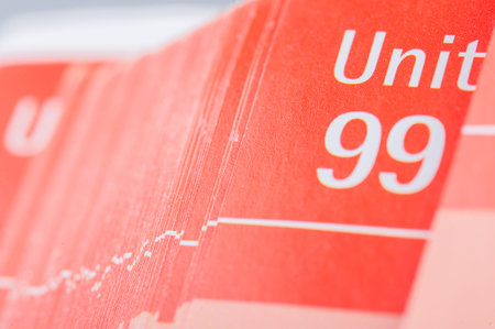 Pages of red school book with unit number ninety nine and white backgroundの写真素材