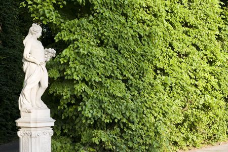 monument of a woman on a green leafes wall backgroundの写真素材