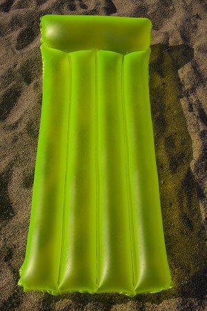 green airbed lying on a sand on a beach in Costa Brava - Spainの写真素材