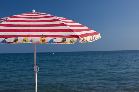 closeup of a beach umbrella on a blue sea and sky backgroundの写真素材