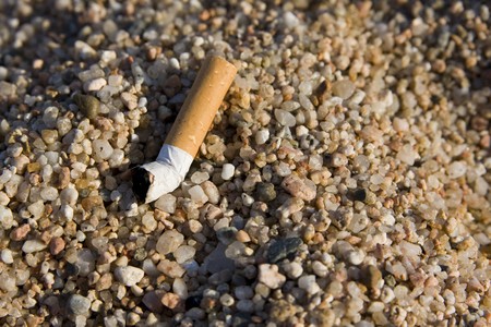 closeup of a cigarette butt found on rocky beachの写真素材