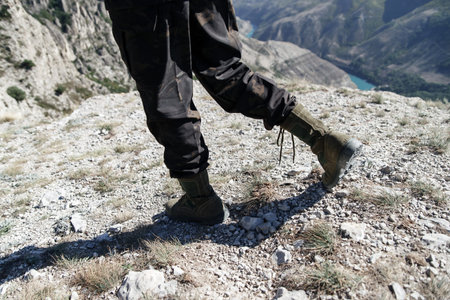 Man in beige clothes and boots sits in the desert. Caucasus, Russia