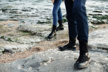 Woman and man in black boots relax in the mountains. Caucasus, Russia