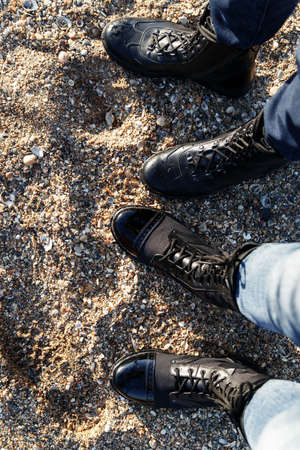 Men's green and beige boots in military style with laces for active walks in the mountains and fishing on a background of sand and grass. Caucasus, Russiaの写真素材