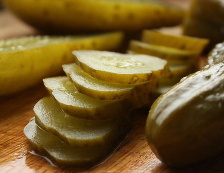 Cucumber in brine sliced on a wooden block.の写真素材