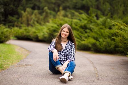 Attractive young woman enjoying her time outside in park with sunset in background.の写真素材