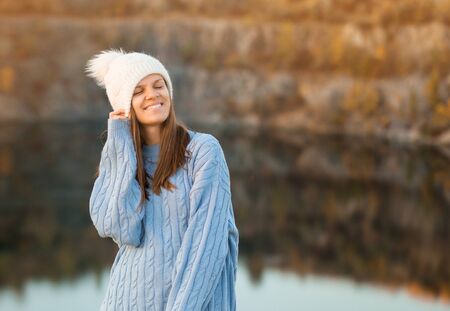 Winter portrait of smilling woman in white hat with big bubo makes funny face outdoorの写真素材