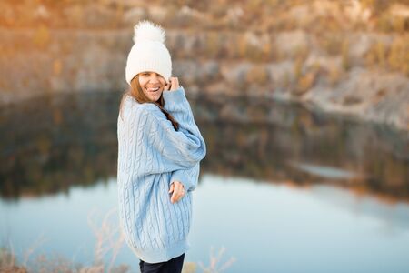 Winter portrait of smilling woman in white hat with big bubo makes funny face outdoorの写真素材