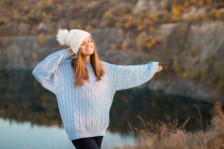 Winter portrait of smilling woman in white hat with big bubo makes funny face outdoorの写真素材