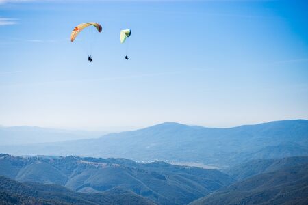 Paragliding group in air sport on top of a mountain. The whole world is in sight. Like a bird, out of gravityの写真素材