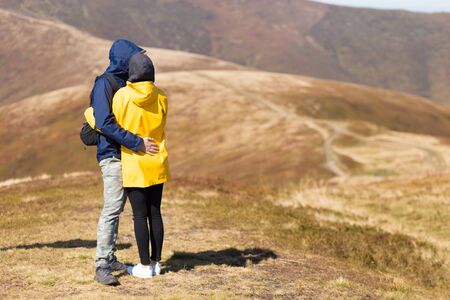 Back view couple of hikers relax on mountain ranges and enjoy beautiful viewの写真素材