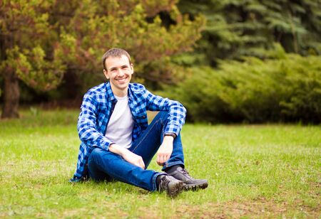 Young man relaxing on grass in parkの写真素材