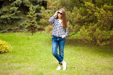 Relaxation in summer. Young girl walk in park in sunglassesの写真素材