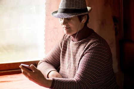 Senior woman using mobile application on smartphone at train and buy ticket online, business travelの写真素材