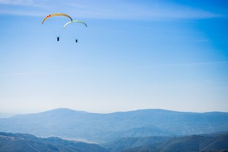 Paragliding group in air sport on top of a mountain. The whole world is in sight. Like a bird, out of gravityの写真素材